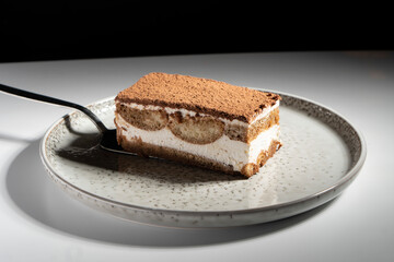 Tiramisu cake dessert served with coffee, biscuit and cocoa on dark background.spoon. Dessert. Food Concept