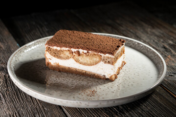 Tiramisu cake dessert served with coffee, biscuit and cocoa on dark background.spoon. Dessert. Food Concept