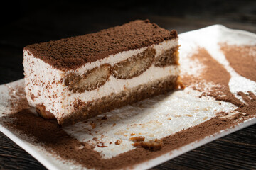Tiramisu cake dessert served with coffee, biscuit and cocoa on dark background.spoon. Dessert. Food Concept