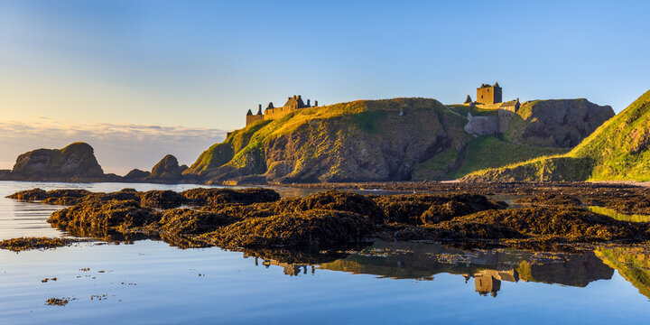 Dunnottar Castle bathed in morning sunlight, taken from Castle Haven near Stonehaven in Aberdeenshire.