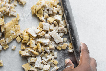 Nigerian Chin chin dough on a white granite countertop, Raw chin-chin on a chopping board, process of making chin chin achomo or klenat