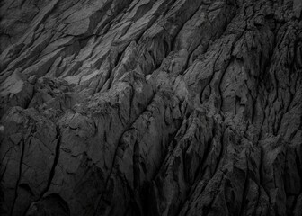 High-Contrast Black and White Close-Up of Rugged Rocky Terrain with Intricate Textures and Dramatic Light Play.