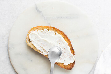 Overhead view of mayo being spread on toast, top view of toast with mayonnaise, process of making a sandwich