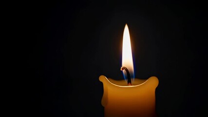 Warm candlelight creates a peaceful ambiance against a dark backdrop, its gentle flame flickering softly, offering a sense of serenity and tranquility