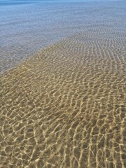 Mesmerizing patterns of sunlight on the surface of clear, shallow water, beautiful texture, sandy bottom, shimmering water, coastal serenity, tranquility and relaxation