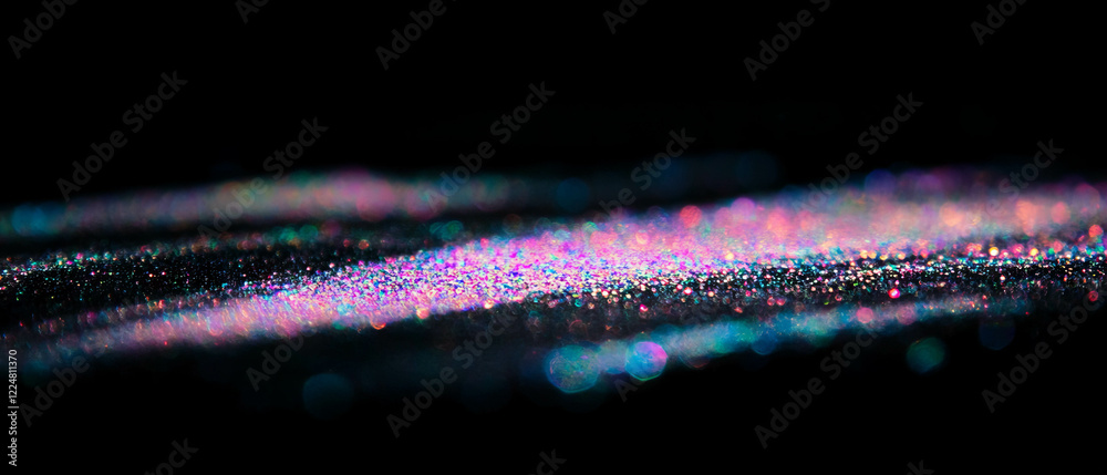 Poster reflecting particles create an iridescent glitter overlay on a dark background