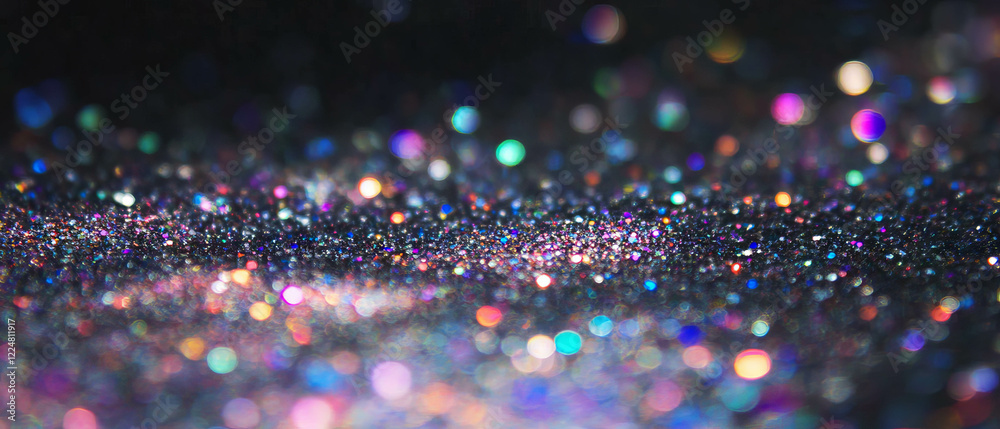 Poster glitter particles create a stunning texture against a dark background in vibrant colors