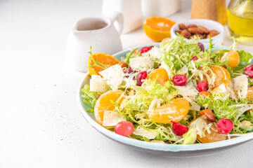 Salad bowl with lettuce, tangerines, nuts and cranberry