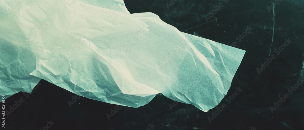 Poster overlay texture of light reflecting paper with sheen against a black background
