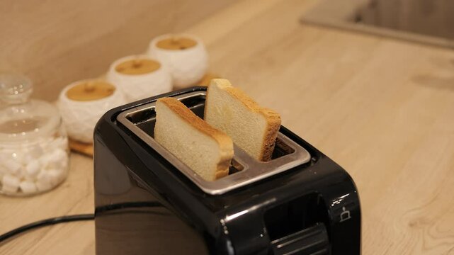  Toasted bread pops up from toaster symbolizing quick and delicious breakfast preparation Crispy toast brings warmth to cozy kitchen mornings Perfect golden toast moment for breakfast lovers 