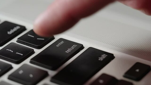 Close up male's finger aggressively presses the enter key several times, deadline comes