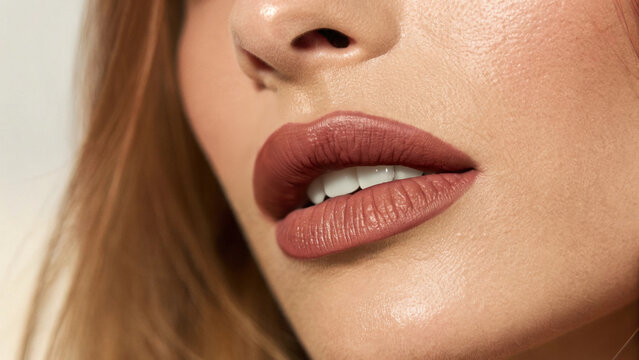 Mocha mousse makeup, 2025 Color Trend. Close-up of a woman's lips with a soft matte finish and natural makeup, highlighting beauty features.