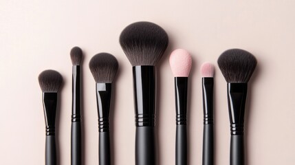 Set of makeup brushes, blush and powder on pastel or beige background