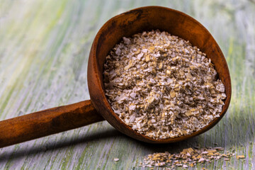 Natural ingredients in a wooden scoop on a textured background showcasing healthy grains and seeds for holistic cooking