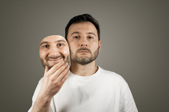 The man hides his true emotions behind a happy mask.
