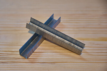 Staples for a stapler on a wooden background