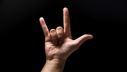 human hand forming the -i love you- sign in american sign language, with the thumb, index, and pinky fingers extended, symbolizing love and connection, set against a dark background with dramatic ligh