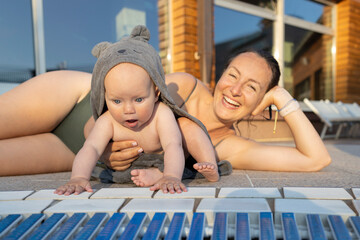 Happy little girl exploring the world while spending time with her mother near the pool. Active...