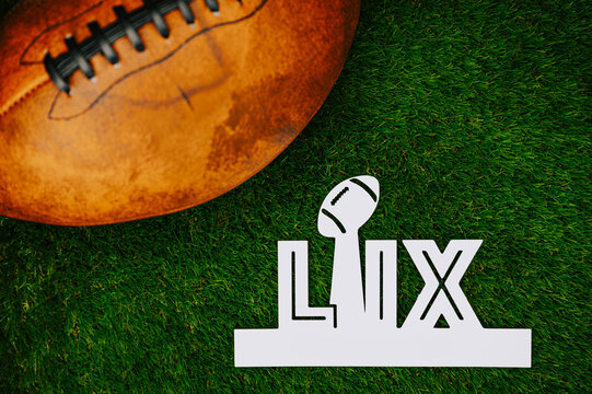 American Football Championship Game LIX for the 2024 season: Kansas and Philadelphia will play in the final on February 10 in New Orleans. A white title LIX and american football ball on green grass.