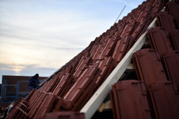 Dachdecker Handwerk liefert Ziegeldach Haus. Dachdecken mit dunkel rotem Dachziegel Muster. Ton Ziegel Textur Banner	