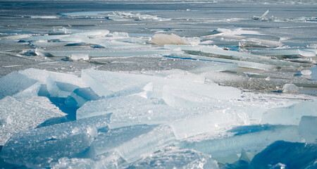 Fototapeta premium Large chunks of ice on the shore of a frozen lake