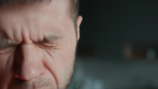 Bad breath from mouth. Close-up of man checking his breath by exhaling into his hand, showing concern about oral hygiene or bad breath