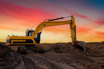 Obraz premium Excavator during excavation at construction site. Backhoe on road work. Heavy Construction Equipment Machines for Earthworks. Digger at bridge construction.