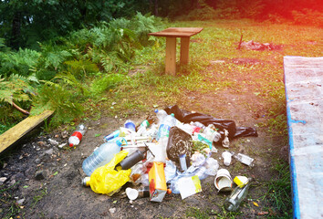 Garbage dump on beach at lake. People throw garbage near lake in nature. Trash at camping resort. Pile of rubbish in nature. Environmental pollution and ecology. Illegal dumping of Garbage near river