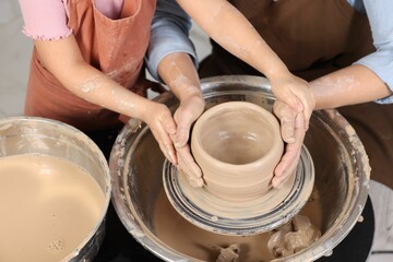 Hobby and craft. Mother with her daughter making pottery indoors, closeup