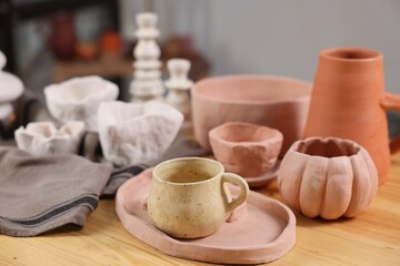 Hobby and craft. Different beautiful pottery on wooden table indoors, closeup