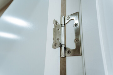 This closeup image showcases a meticulously crafted door hinge affixed to a pristine white door, highlighting its intricate design that ensures smooth and flawless operation when used