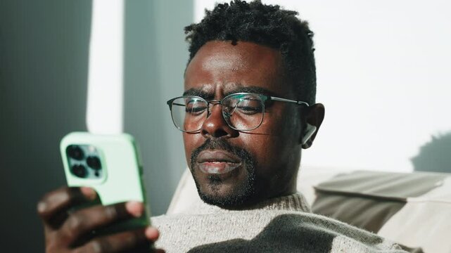 Man listens music in smartphone at home.