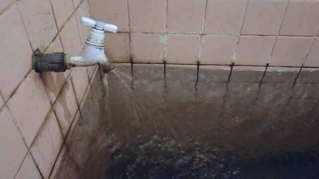 Water faucet leaking. outdated water faucet. old water tank.