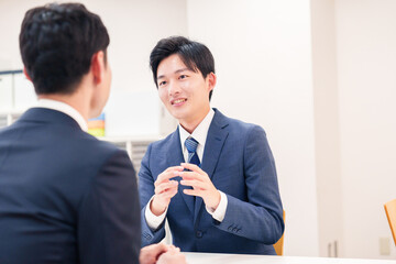 窓口で来客の対応をするビジネスマン