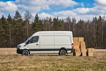 Delivery Van Parked in Nature Surrounded by Cardboard Boxes on a Sunny Day