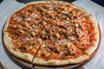 Delicious pizza topped with olives, mushrooms, and ham slices