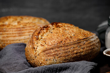 Artisan bread with seeds and of flour on wooden table. 