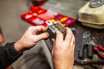 Fototapeta premium Car electric mechanic working on electrical wiring. Fixing electrical system and wiring of engine computer block for machine operations. replacing damaged electrical components of engine computer