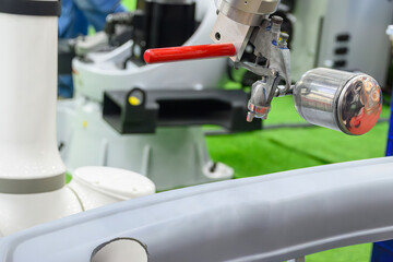 Close up scene the automatic painting robot working with automotive parts.