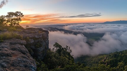 Breathtaking panoramic view of mountains, clouds, and trees during a stunning sunset