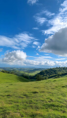 Green hill landscape under blue sky with white clouds, serene nature background  -