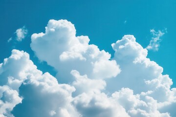 Naklejka premium Fluffy cumulus clouds drift across a vibrant blue sky.