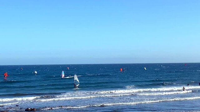 Many windsurfers riding waves during windy day in El Medano bay, Tenerife, Canary Islands, Spain,4K
