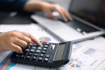 Finance bank tax expense accounting budget money businessman hand use calculator Financial calculate accountant close up calculator with graph chart write office desk Business expense analysis saving