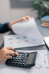 Finance bank tax expense accounting budget money businessman hand use calculator Financial calculate accountant close up calculator with graph chart write office desk Business expense analysis saving