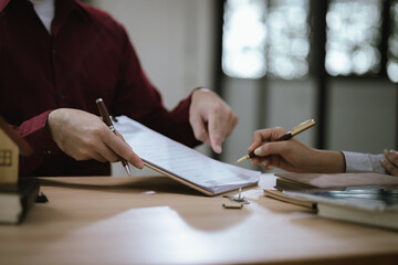 Real estate professionals meet with clients to discuss real estate investing, sales, and mortgage options. They review contracts to ensure a safe and successful transaction.
