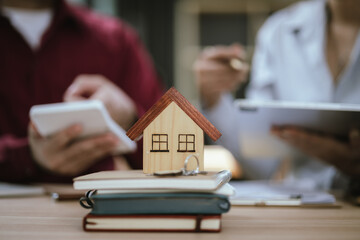 Fototapeta premium Real estate agent hands keys to new homeowner, symbolizing successful home purchase. Documents, contracts, home ownership, and real estate transactions.