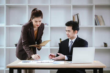Business team two colleagues discussing new plan financial graph data on office table with laptop and digital tablet.