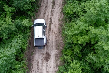 Fototapeta premium An aerial view captures a pickup truck parked on a dusty forest road, exemplifying adventure and the spirit of exploration in beautifully remote natural surroundings.