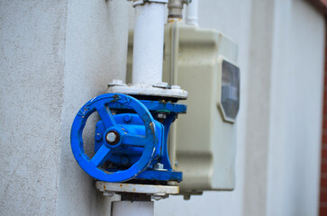 Blue valve on the pipeline with gas meter at the back.